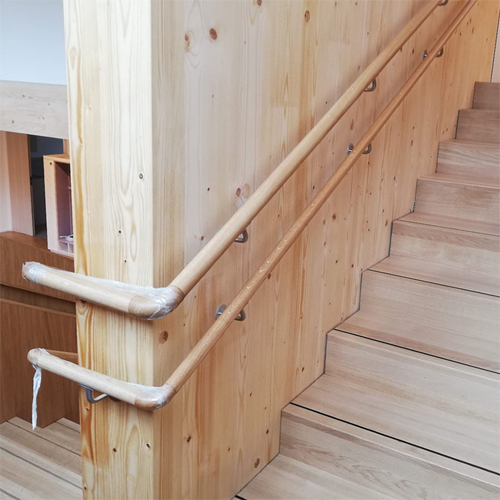 Holztreppe mit Treppenlauf und Antirutschschiene auf den Stufen