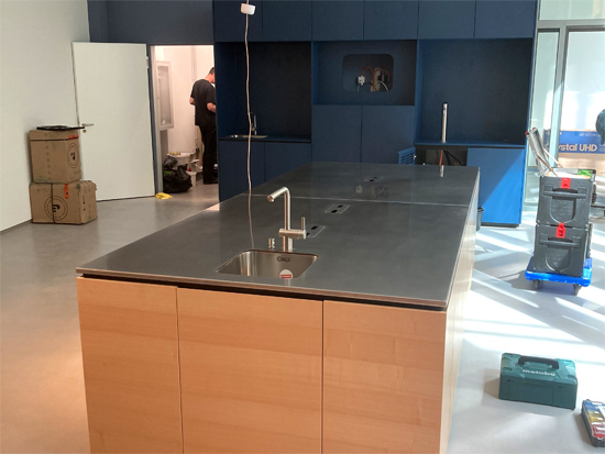 Objekteinrichtung Showk�che Vollkernarbeitsplatte, eingefr�stes Waschbecken r�ckseitig verklebt, M�llkipper aus Aluminium, Arbeitsplatte aus Edelstahl mit Kabelausschnitten